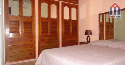 El dormitorio principal con una cama doble y armario empotrado