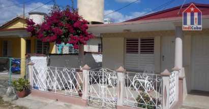 El hostal desde el exterior con una terraza y las mecedoras ubicuas